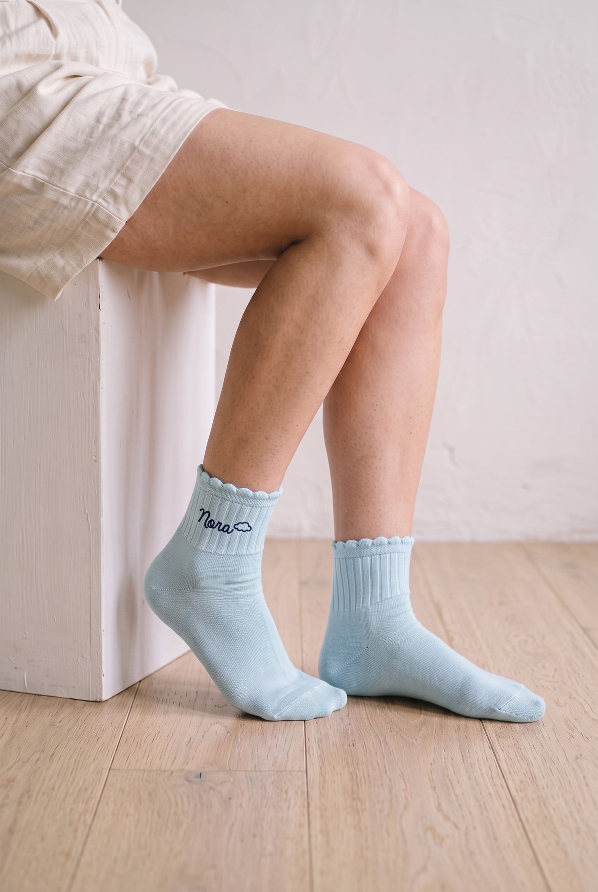 Model wearing baby blue embroidered ruffle ankle socks