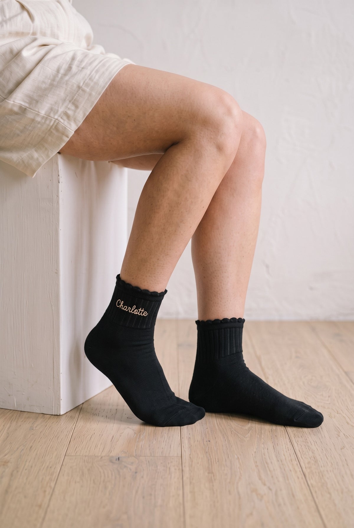 Model wearing black embroidered ruffle ankle socks