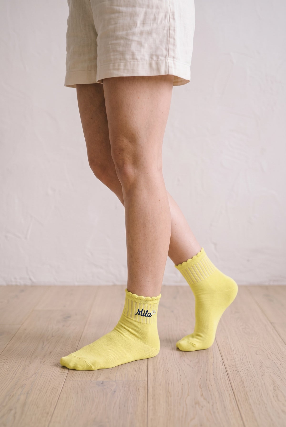 Model wearing lemon yellow embroidered ruffle ankle socks, second view