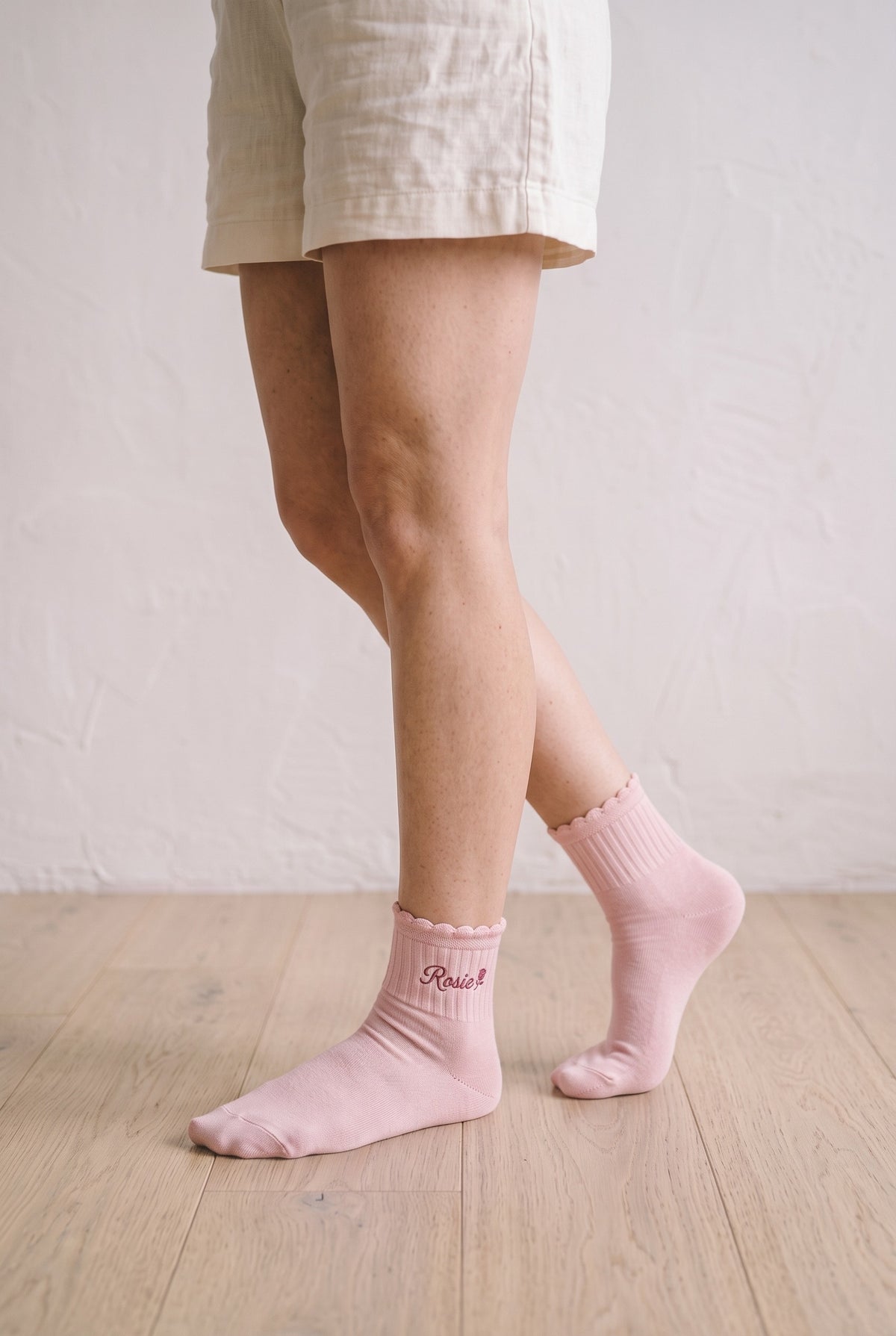 Model wearing powder pink embroidered ruffle ankle socks, second view
