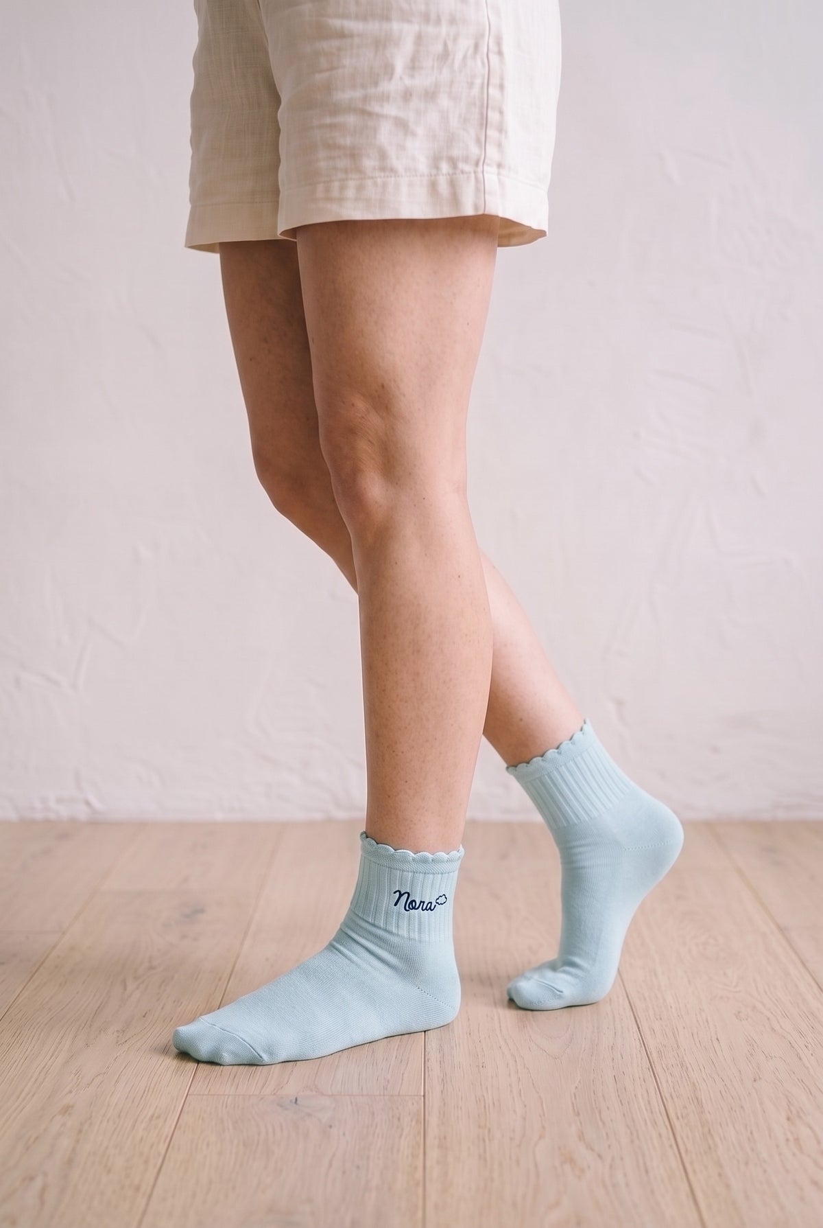 Model wearing baby blue embroidered ruffle ankle socks, second view