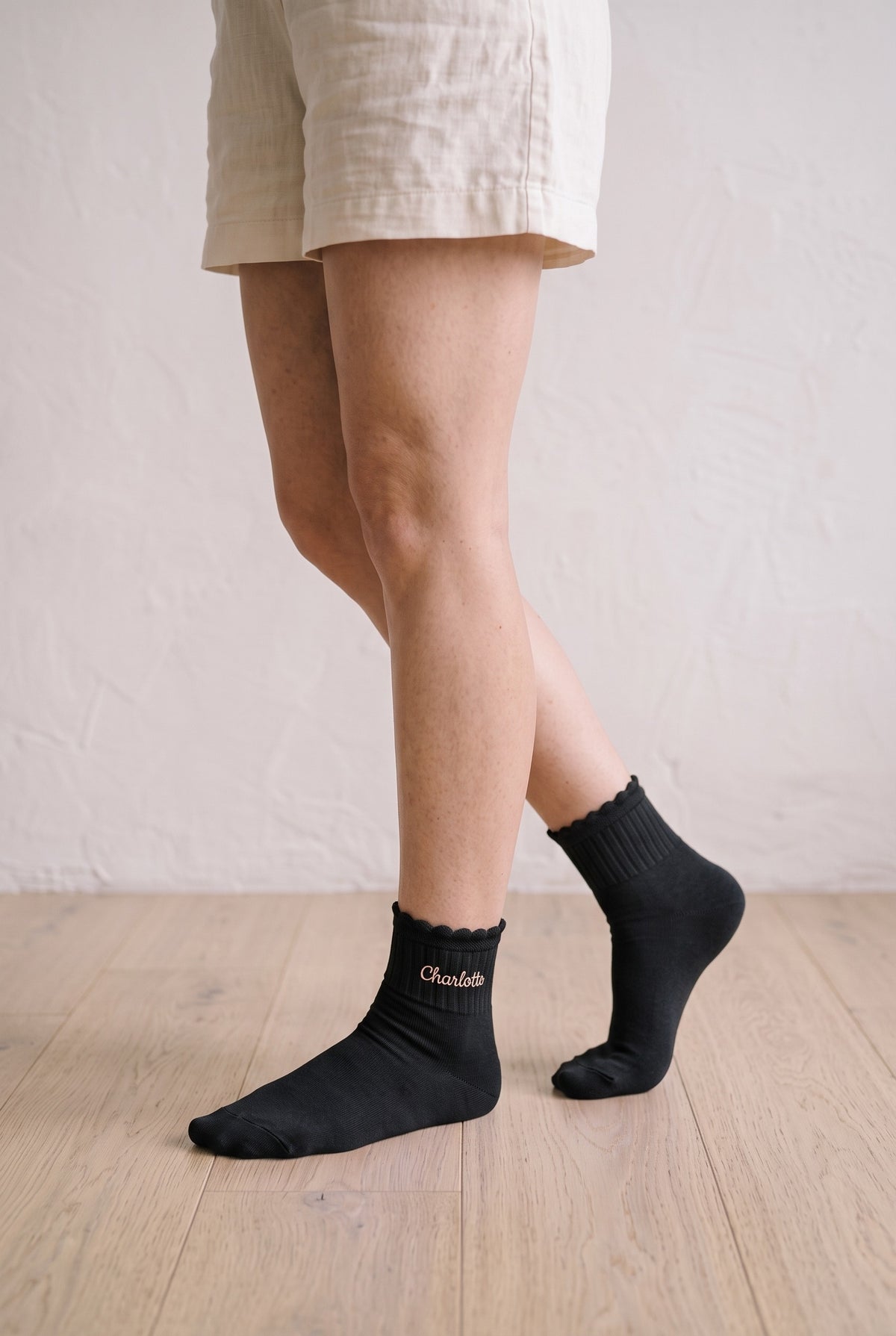 Model wearing black embroidered ruffle ankle socks, second view