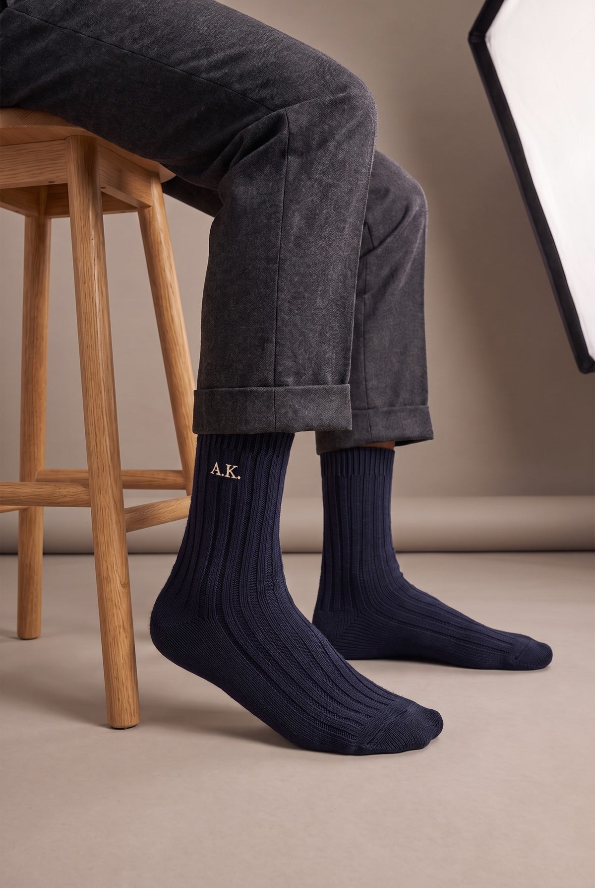 Model wearing navy embroidered men's wool socks
