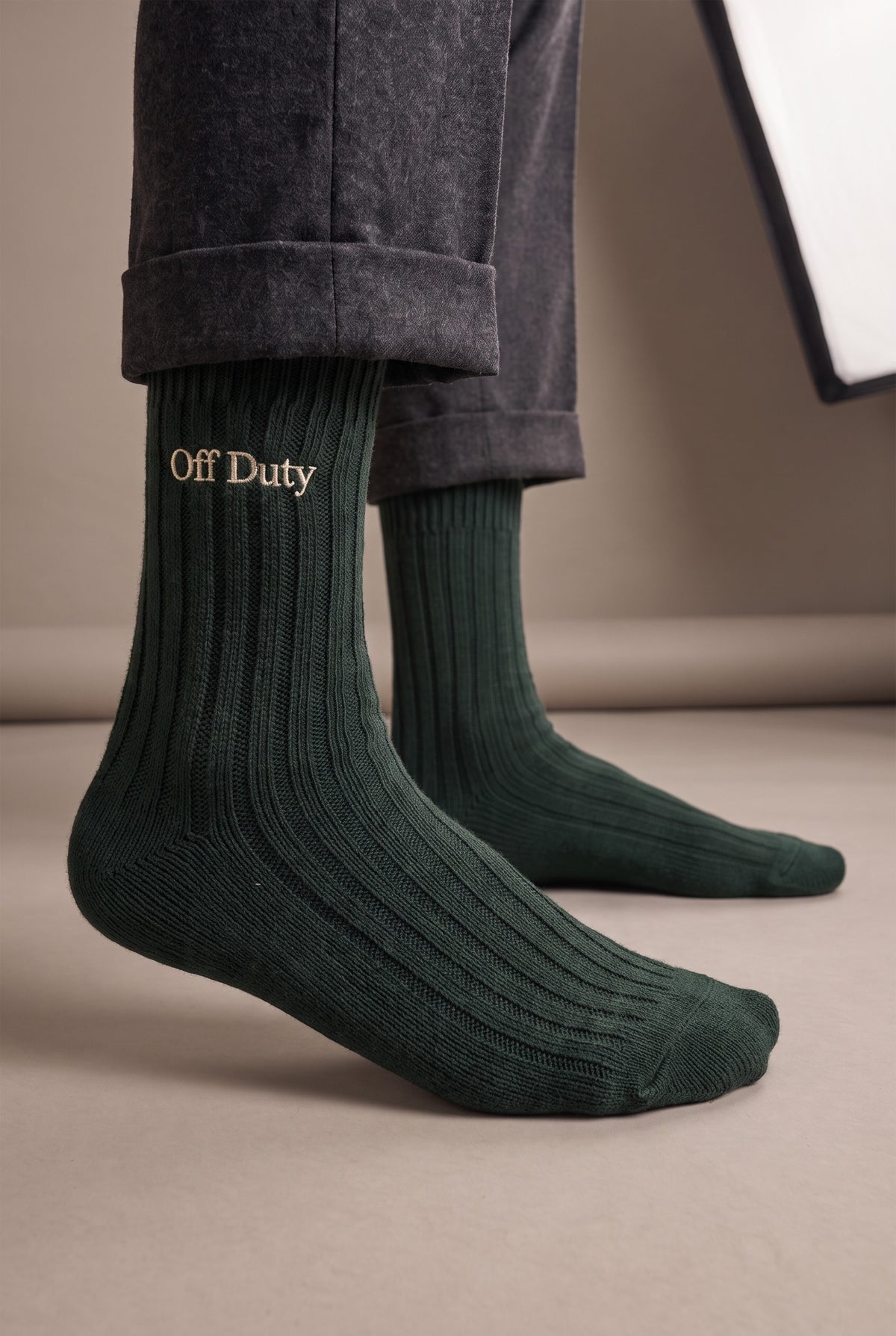 Model wearing green embroidered men's wool socks, second view
