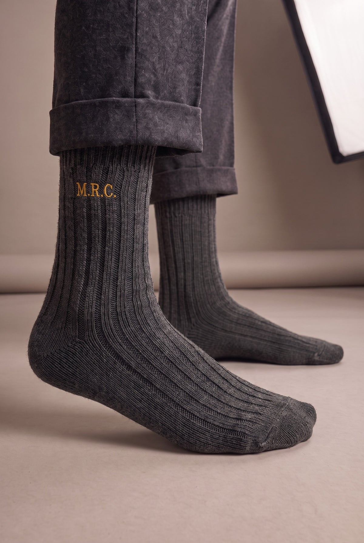 Model wearing charcoal embroidered men's wool socks, second view
