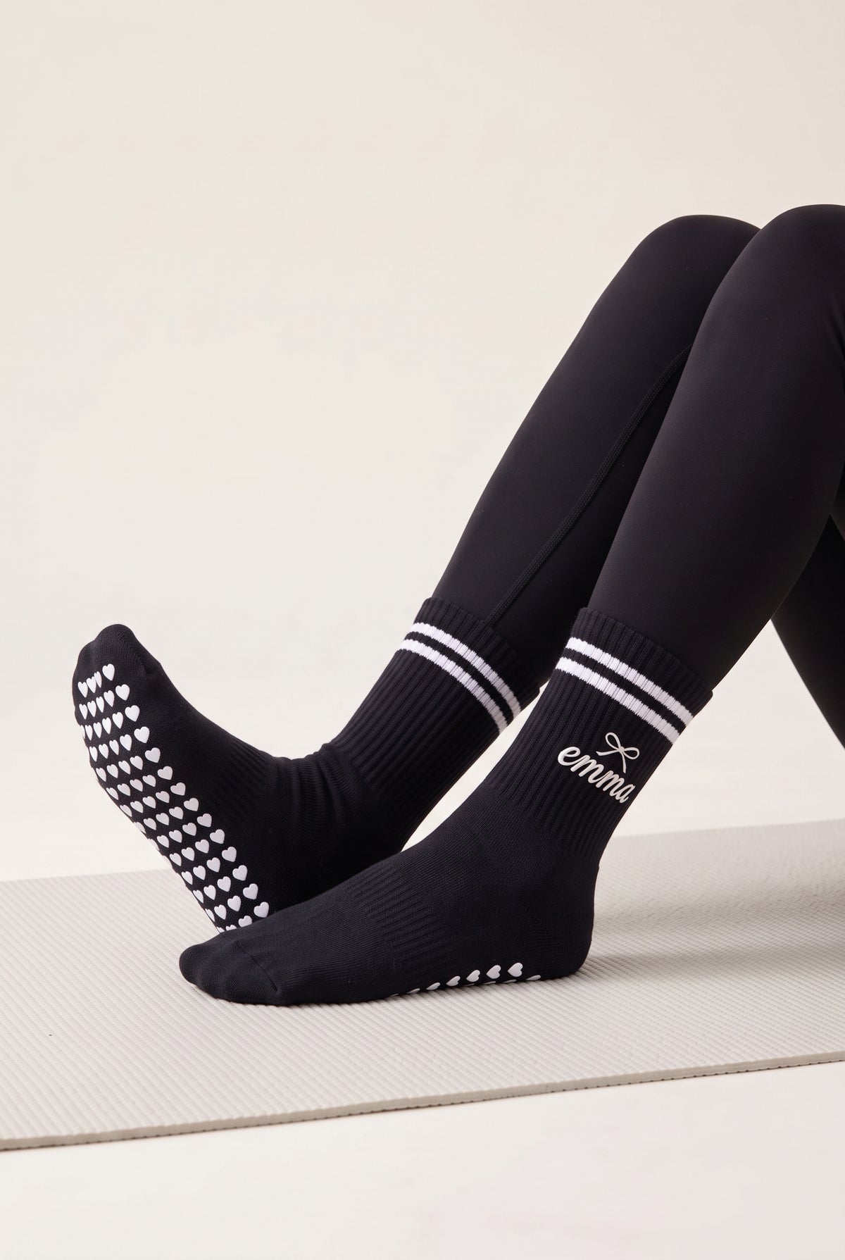 Model wearing black crew pilates grip socks on a mat
