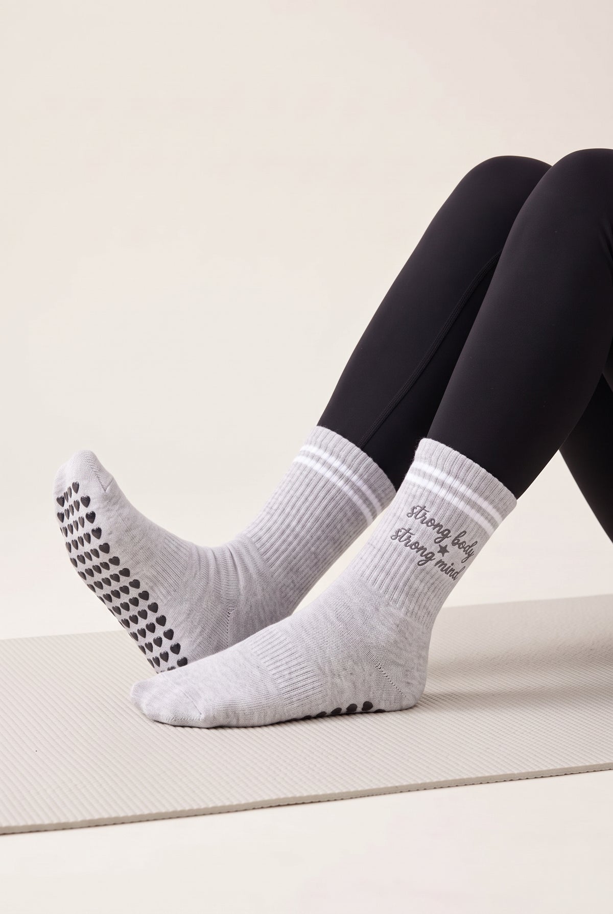 Model wearing grey crew pilates grip socks on a mat