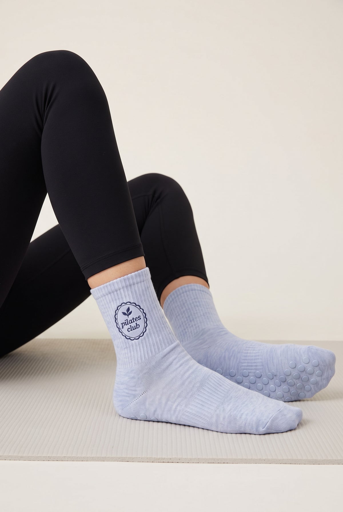 Model wearing baby blue embroidered dot grip pilates socks