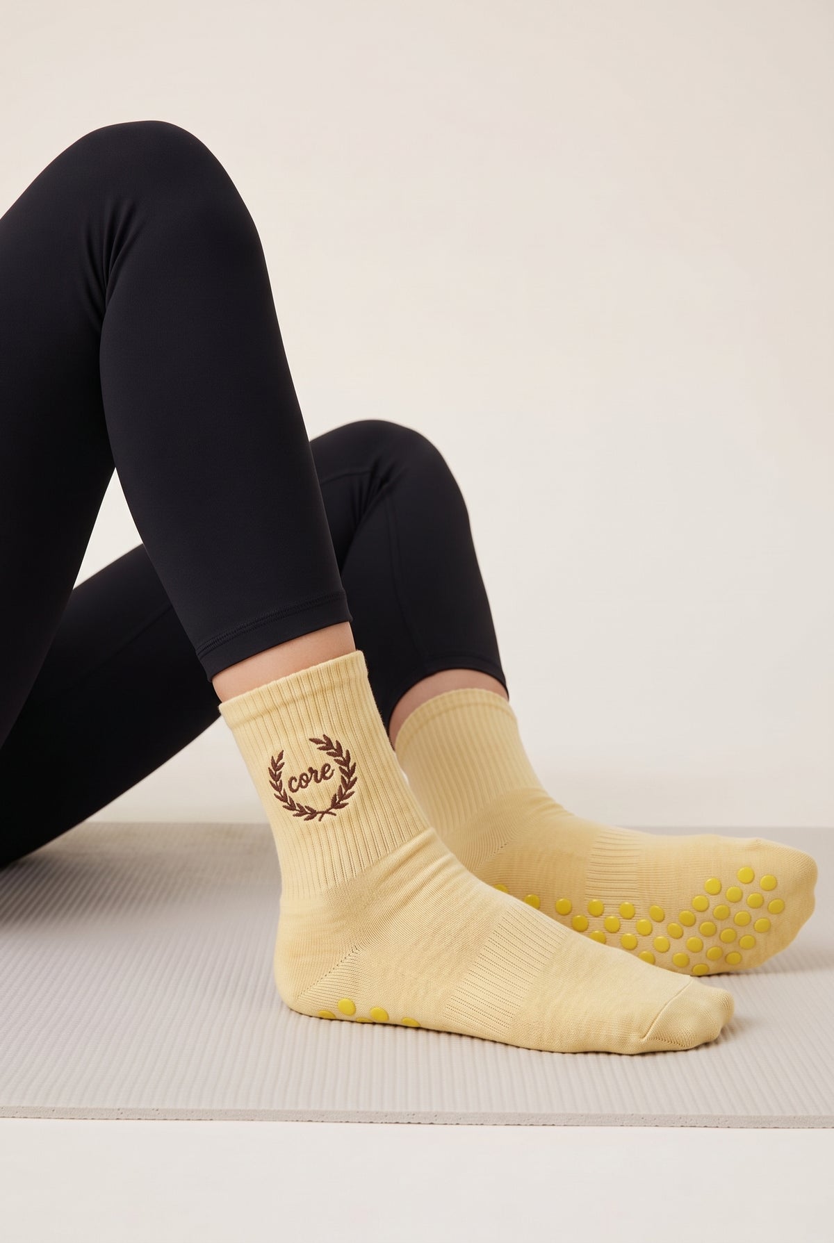 Model wearing yellow embroidered dot grip pilates socks