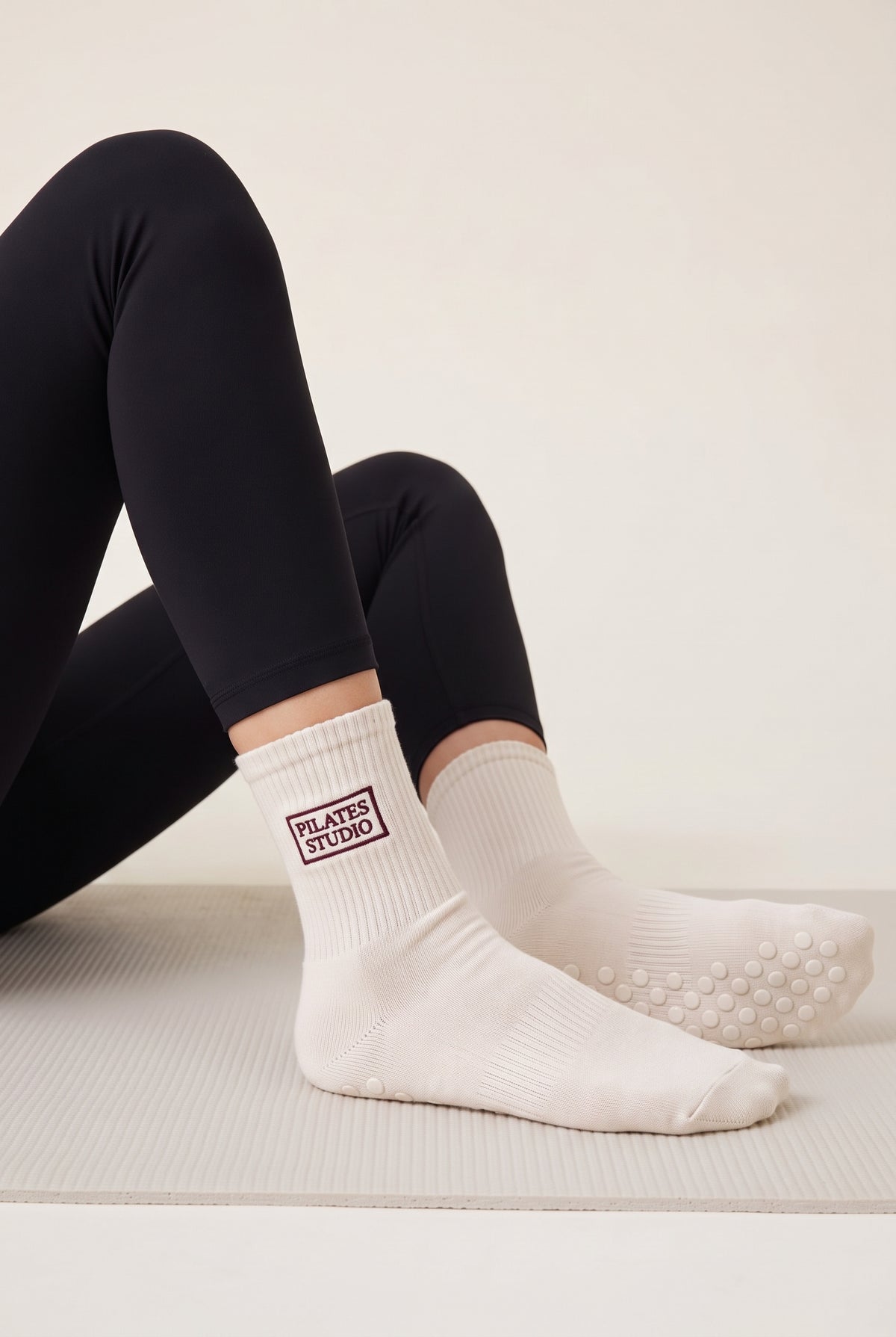 Model wearing off white embroidered dot grip pilates socks