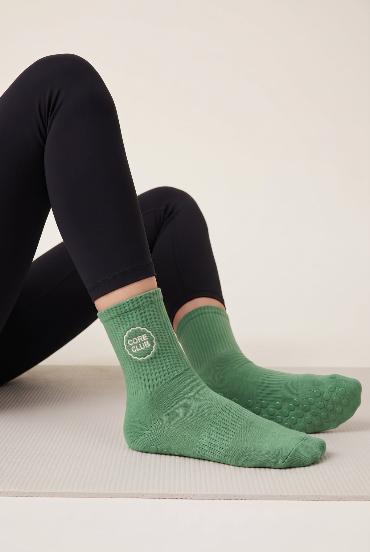 Model wearing green embroidered dot grip pilates socks