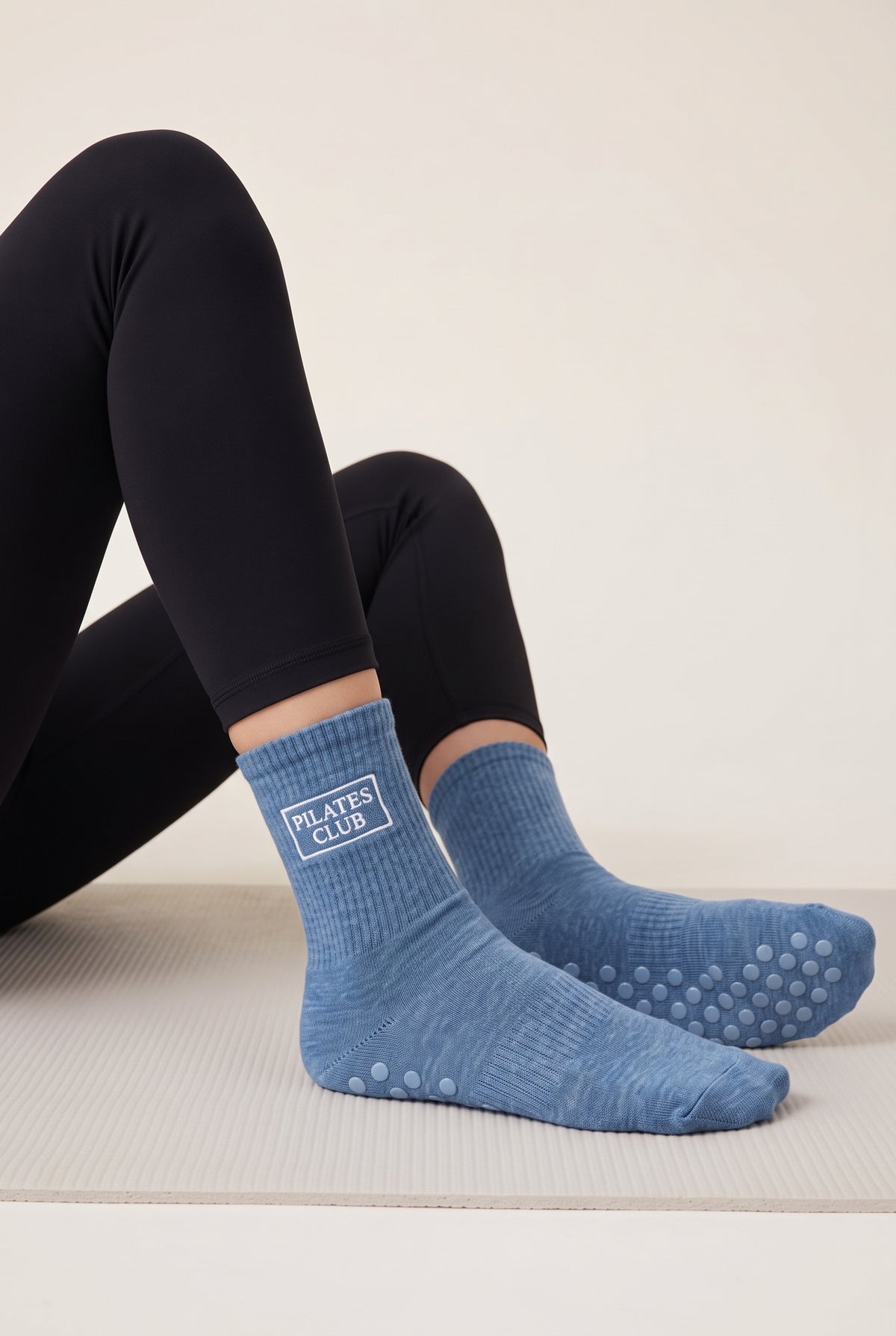 Model wearing blue embroidered dot grip pilates socks