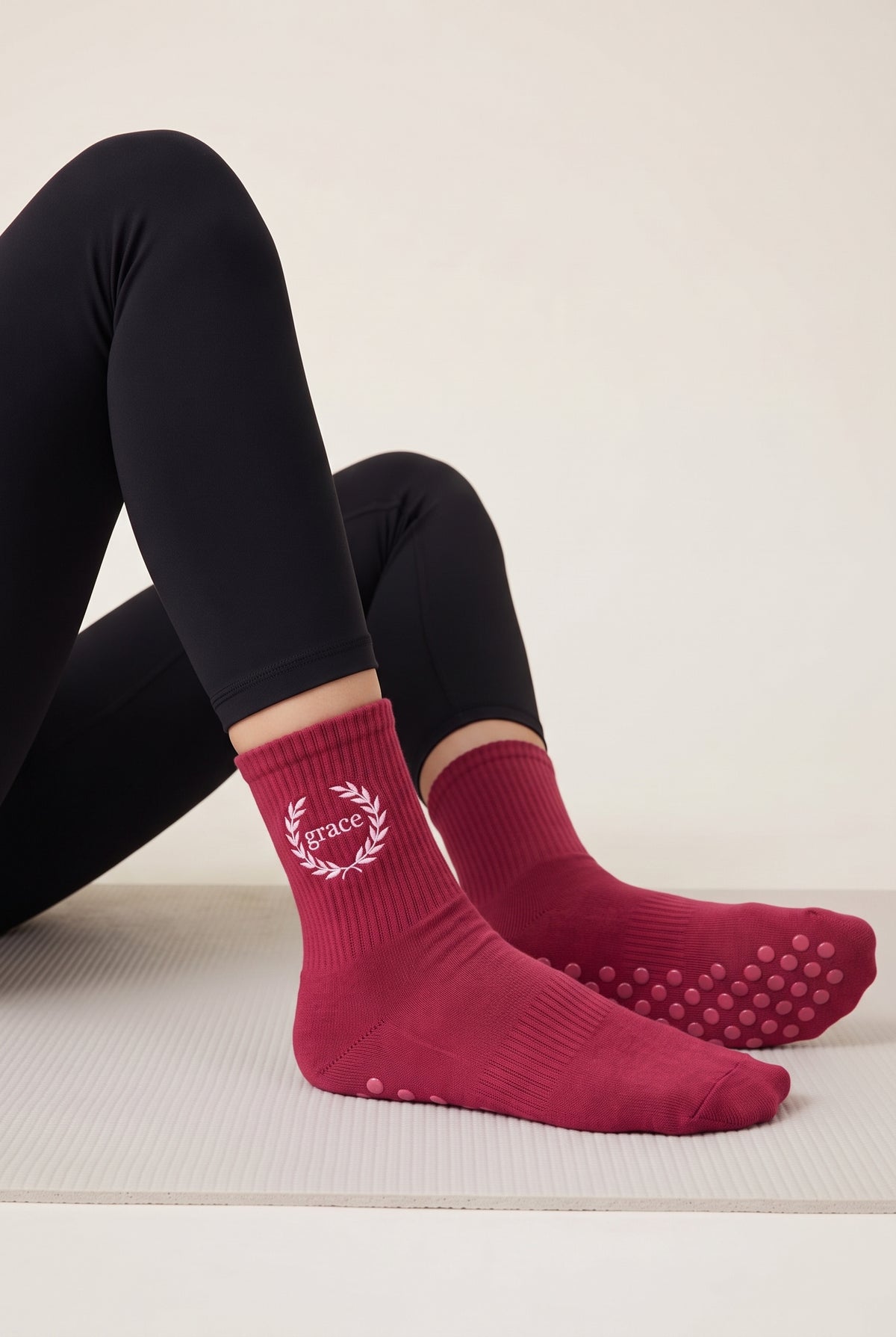 Model wearing berry embroidered dot grip pilates socks
