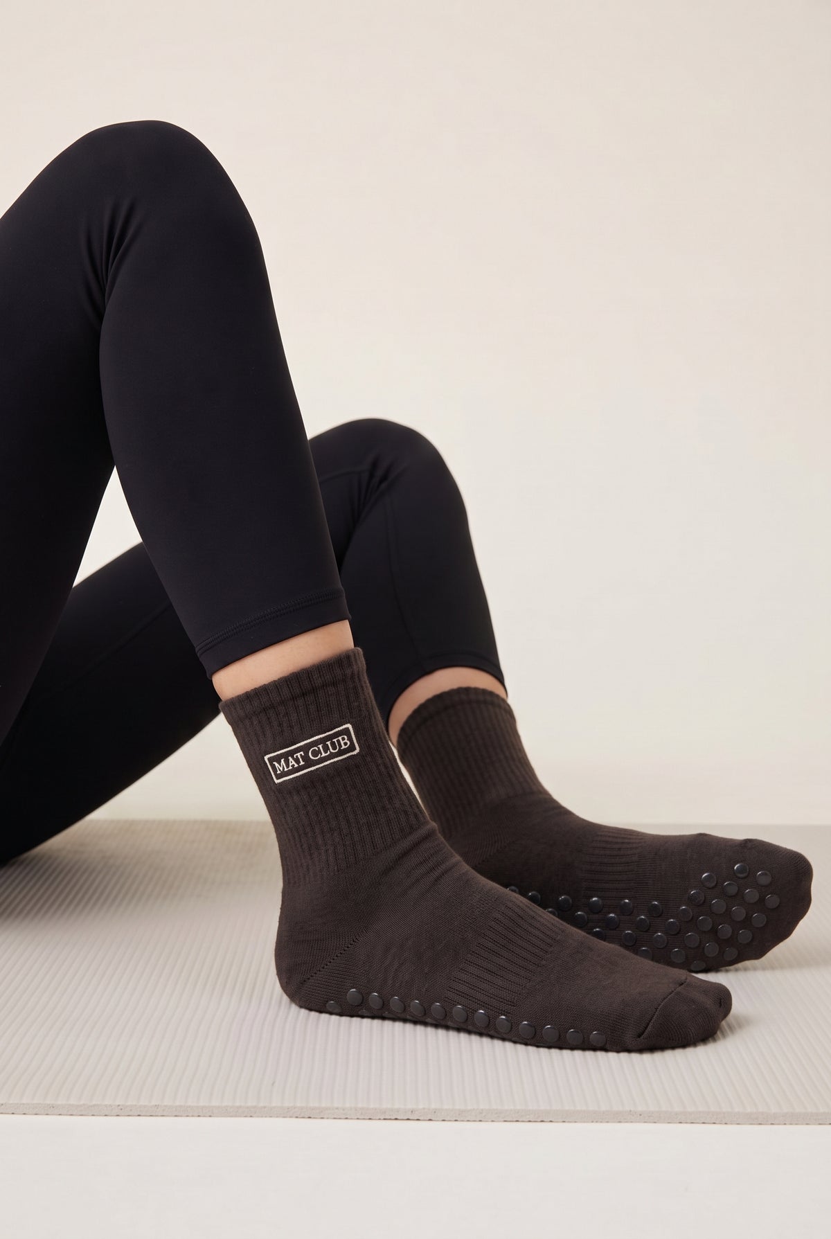 Model wearing brown embroidered dot grip pilates socks