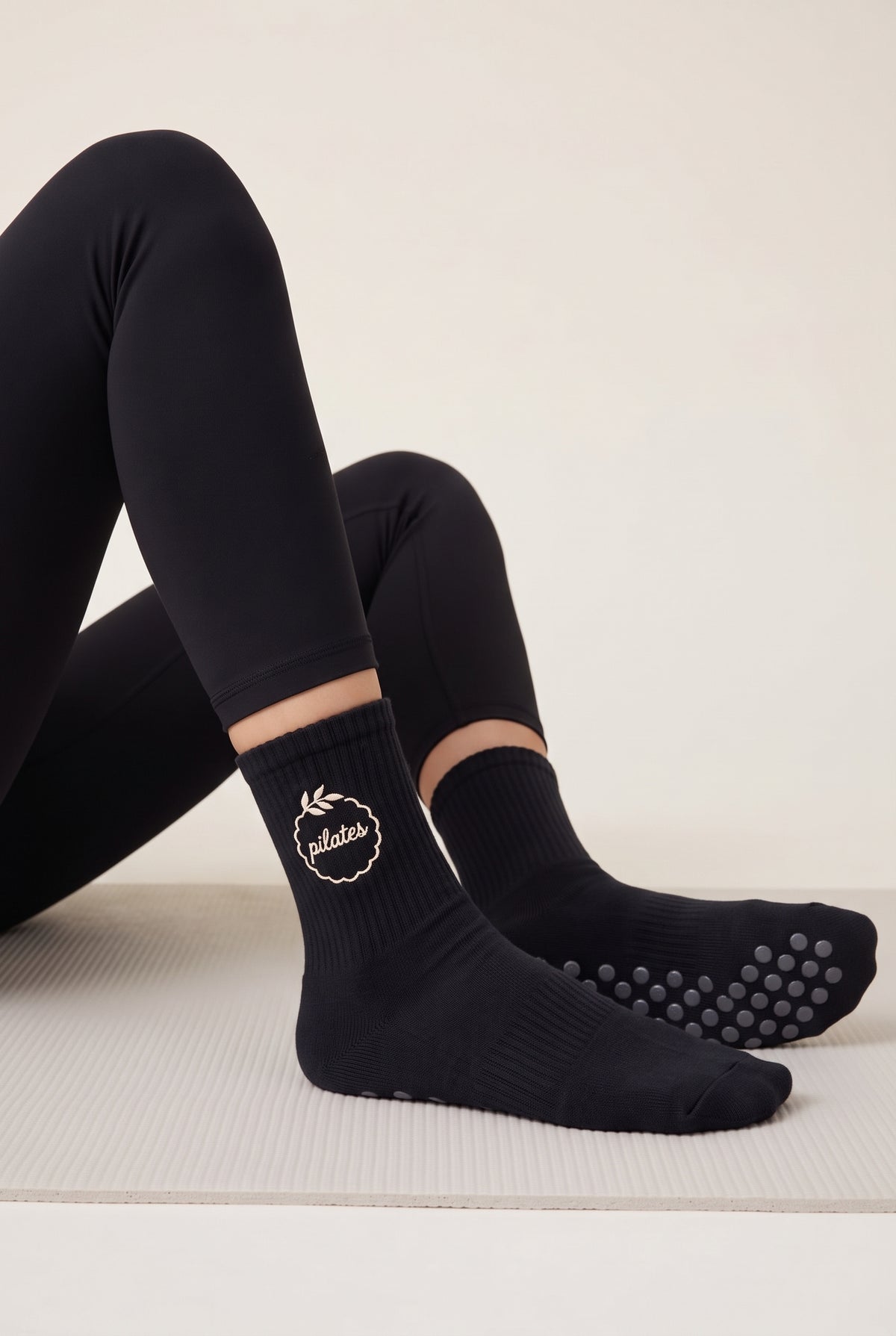 Model wearing black embroidered dot grip pilates socks