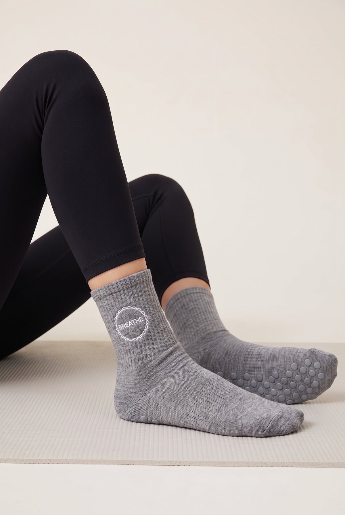 Model wearing grey embroidered dot grip pilates socks