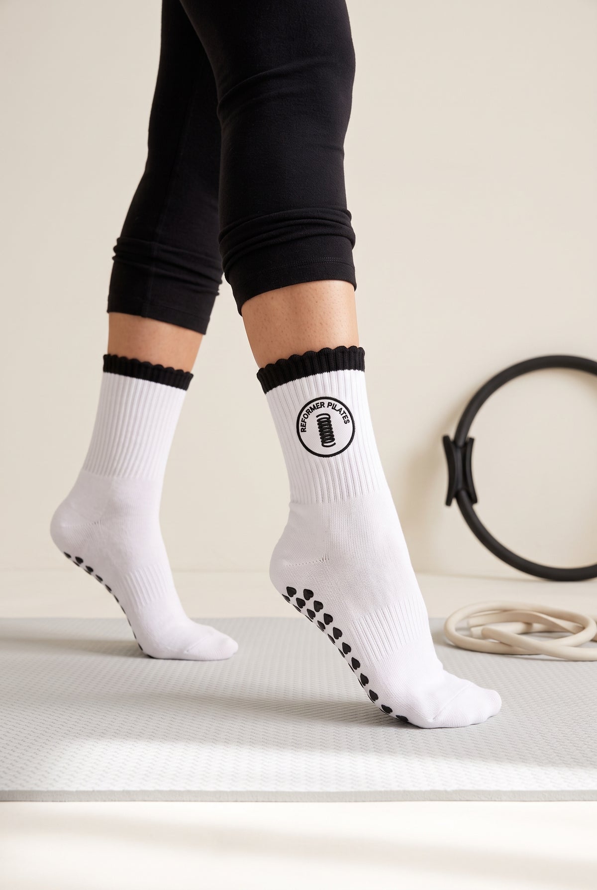 Black ruffle pilates grip socks, worn in a pilates studio — embroidered to order