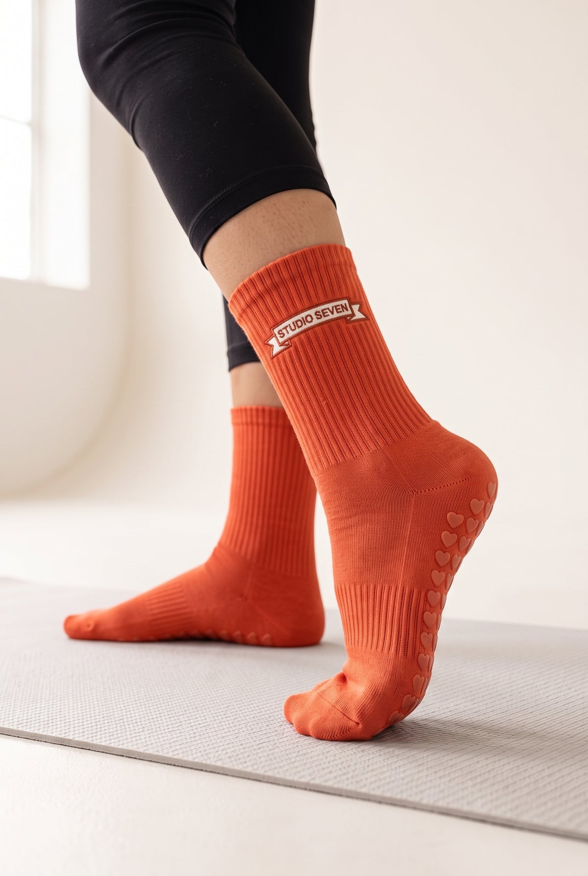 Orange pilates grip socks, worn, seen from the heel — embroidered to order