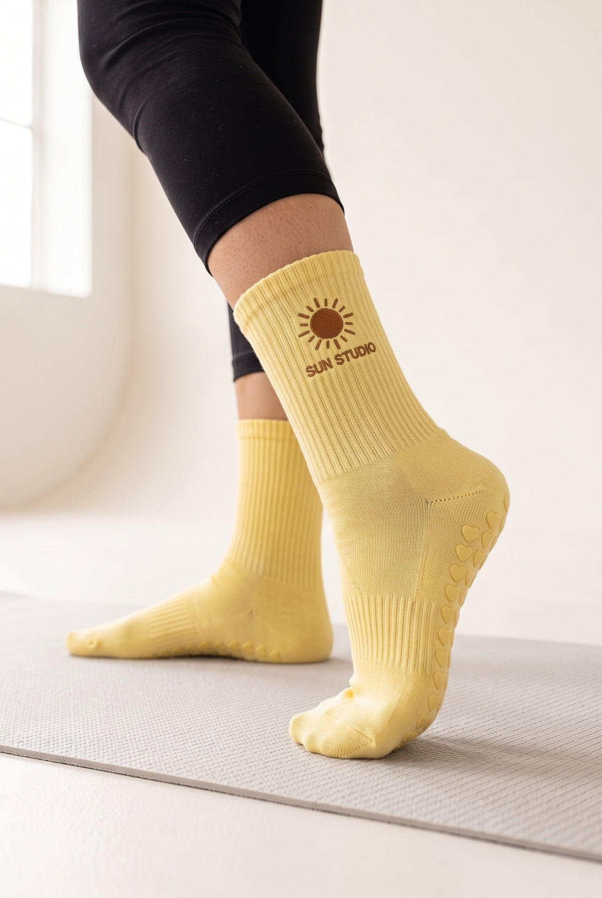 Yellow pilates grip socks, worn, seen from the heel — embroidered to order